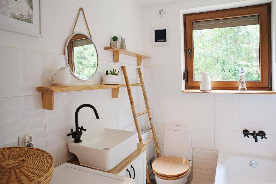 Helles Badezimmer mit Holzregalen, einem minimalistischen Waschbecken und einer großen Fensteransicht auf die Natur
