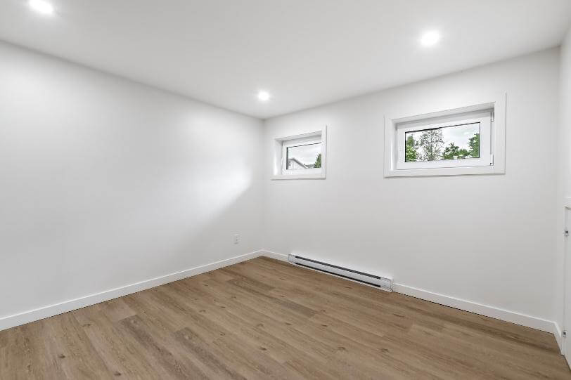 Zwei Fenster in einem leeren, weißen Raum mit Blick ins Freie