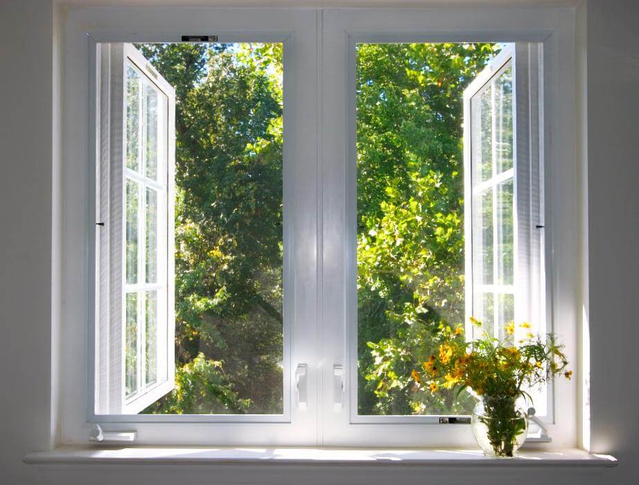 Zwei nach außen geöffnete Fenster mit Blick in die Natur