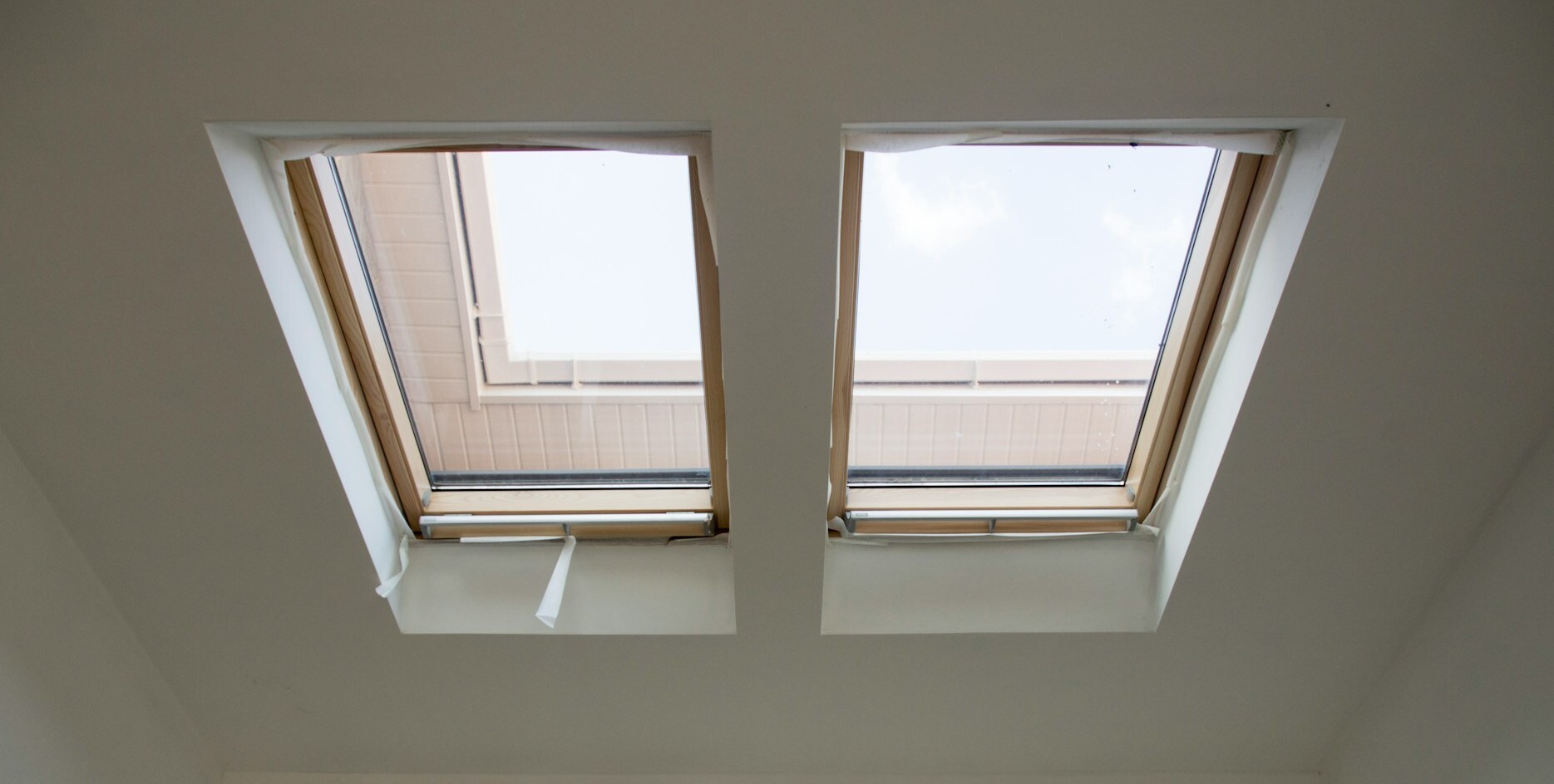 Zwei wei&szlig;e, frisch eingebaute Dachfenster.