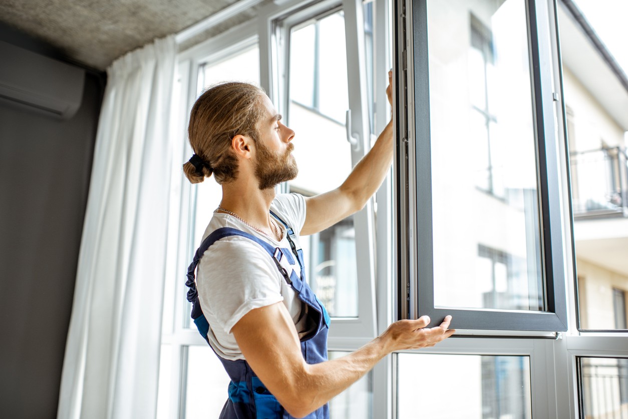 Foto von einem Fensterinstallateur bei meinfenster24.de, der online gekaufte Fenster zu Hause einbaut.