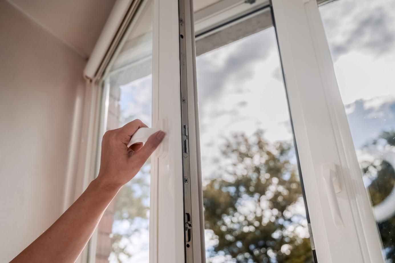 Hand bedient einen Fenstergriff
