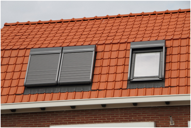 Ein Dach mit drei Dachfenstern mit Rollläden.