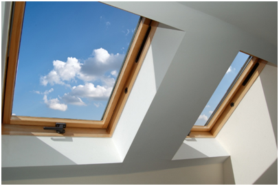 Alt-Attribut: Zwei Dachflächenfenster mit Holzrahmen und Blick auf blauen Himmel mit Wolken