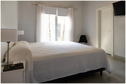 Gästezimmer mit Fenster und weißen Vorhängen