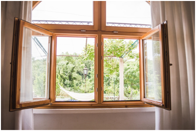Holzfenster mit Mittelpfosten und Ausblick auf Garten