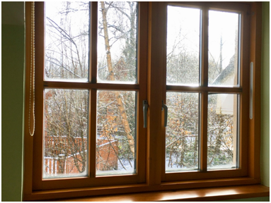 Zweiflügeliges Holzfenster mit Setzholz bei Winterwetter