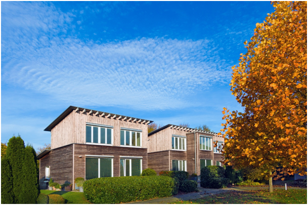 Passivh&auml;user mit Holzfassade, bodentiefen Kunststofffenstern und Hecken