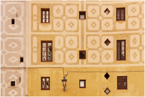 Hausfassade mit Ornamenten, kleinen Rautenfenstern und weiteren Holzfenstern