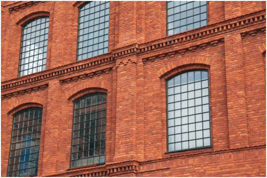 Backsteinfassade mit großen Industriefenstern in schwarzem Metallrahmen