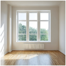 Leerer Raum mit hellem Parkettboden und großem Sprossenfenster