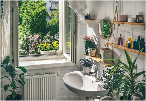 Badezimmer mit ge&ouml;ffnetem Fenster und umfangreicher Pflanzendekoration