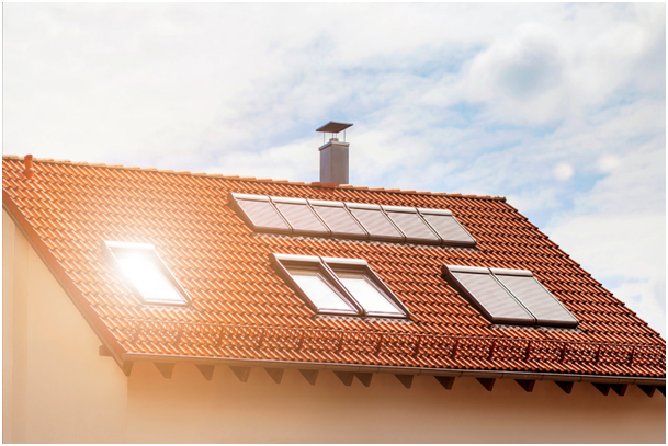 Sonne scheint auf ein Dachfenster, während bei weiteren Fenstern Rollläden angebracht sind