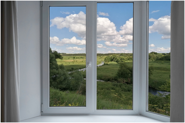 Fensterfront mit linkem Fensteranschlag und Blick auf Wiesen, Bäume und einen Fluss
