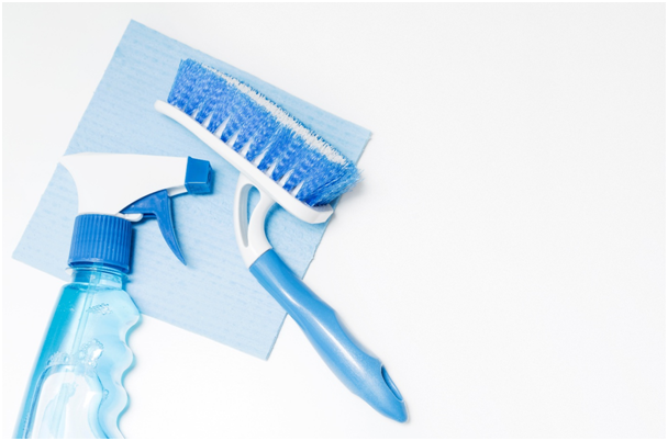 Tuch, auf dem eine Reinigungsbürste und eine Flasche mit Flüssigreiniger liegen