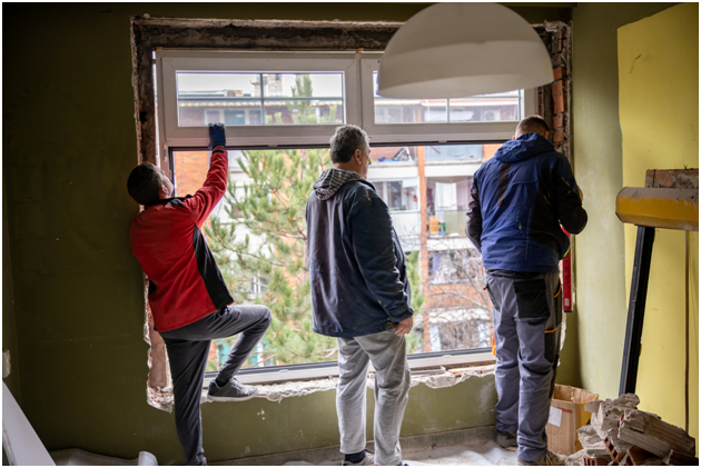 Drei Arbeiter installieren ein neues Kunststofffenster