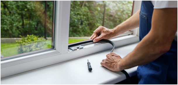 Ein Handwerker setzt eine neue Gummidichtung in ein Kunststofffenster ein