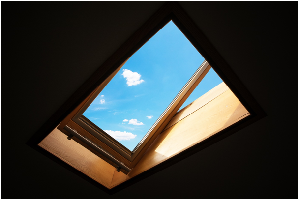 Dachfenster von innen mit Blick auf den blauen Himmel.