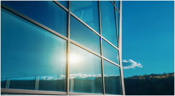 Au&szlig;enansicht auf eine Fensterfront mit Sonnenspiegelung
