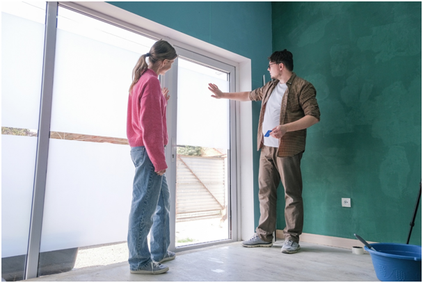 Eine Frau und ein Mann betrachten ein Fenster mit Milchglasfolie in einem Wohnraum