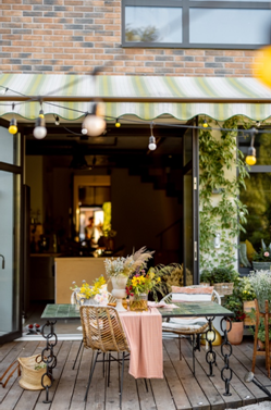 Eine Terrasse mit einer ausgefahrenen Markise und gedecktem Tisch