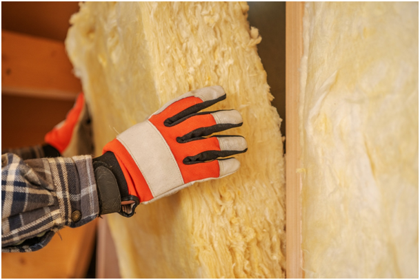 Arbeiter installiert eine Mineralwolled&auml;mmung in der Wand.