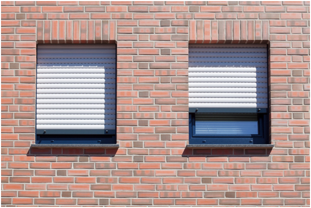 Hauswand und zwei Fenster mit halb geschlossenen Rollladen