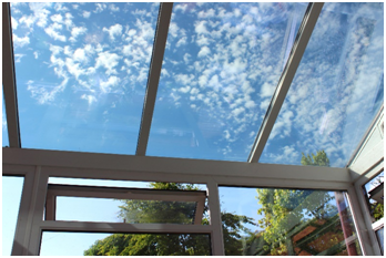 Wintergarten mit Glasdach und Blick in den Himmel