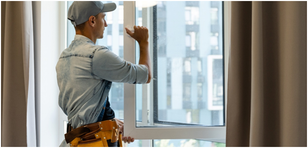 Mann, der einen Fenstergriff bei geöffnetem Fenster bedient
