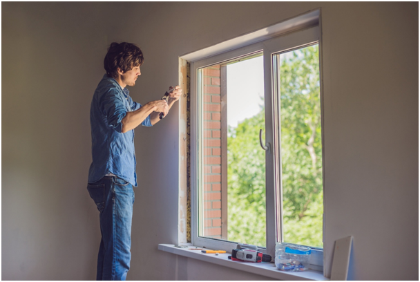 Handwerker beim Einbau eines Fensters mit Blick ins Gr&uuml;ne