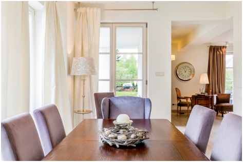 Helles Esszimmer mit großen Fenstern und eleganter Einrichtung
