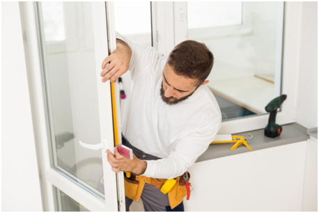 Handwerker misst Fensterrahmen zur fachgerechten Montage