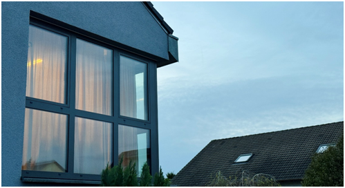 Beleuchtete Fensterfront im Morgengrauen