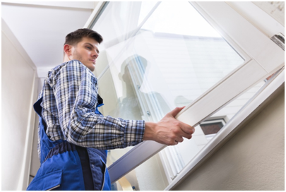 Handwerker beim Einbau eines weißen Kunststofffensters