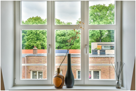 Fenster mit Vasen davor und Blick auf das Nachbarhaus.