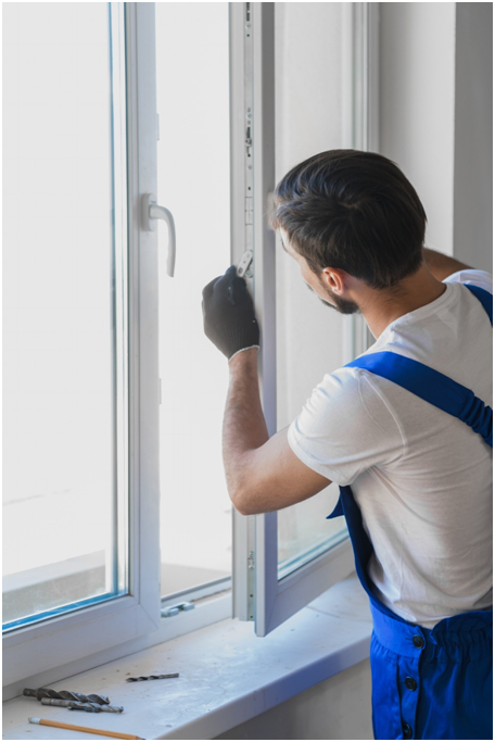 Fensterinstallateur montiert ein Kunststofffenster.