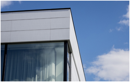 Moderne Glasfassade mit großen Fenstern und blauer Himmel