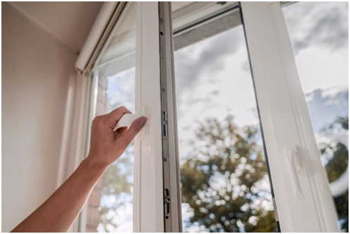 Eine Frau öffnet ein Fenster