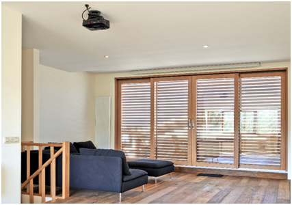 Modernes Wohnzimmer mit wohnlicher Atmosphäre dank Fensterfront aus Holz-Einbaufenstern.