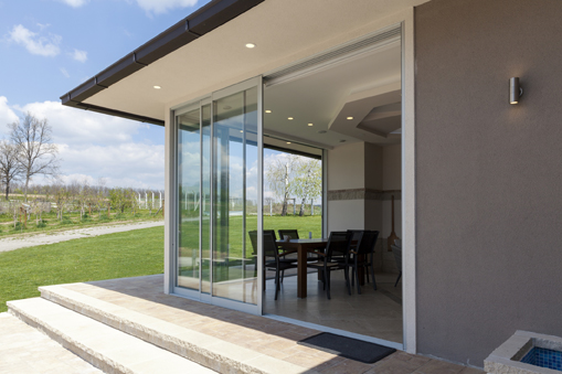 Foto einer modernen Schiebe-Terrassentür, die auf einen Garten und in ein modernes Esszimmer führt