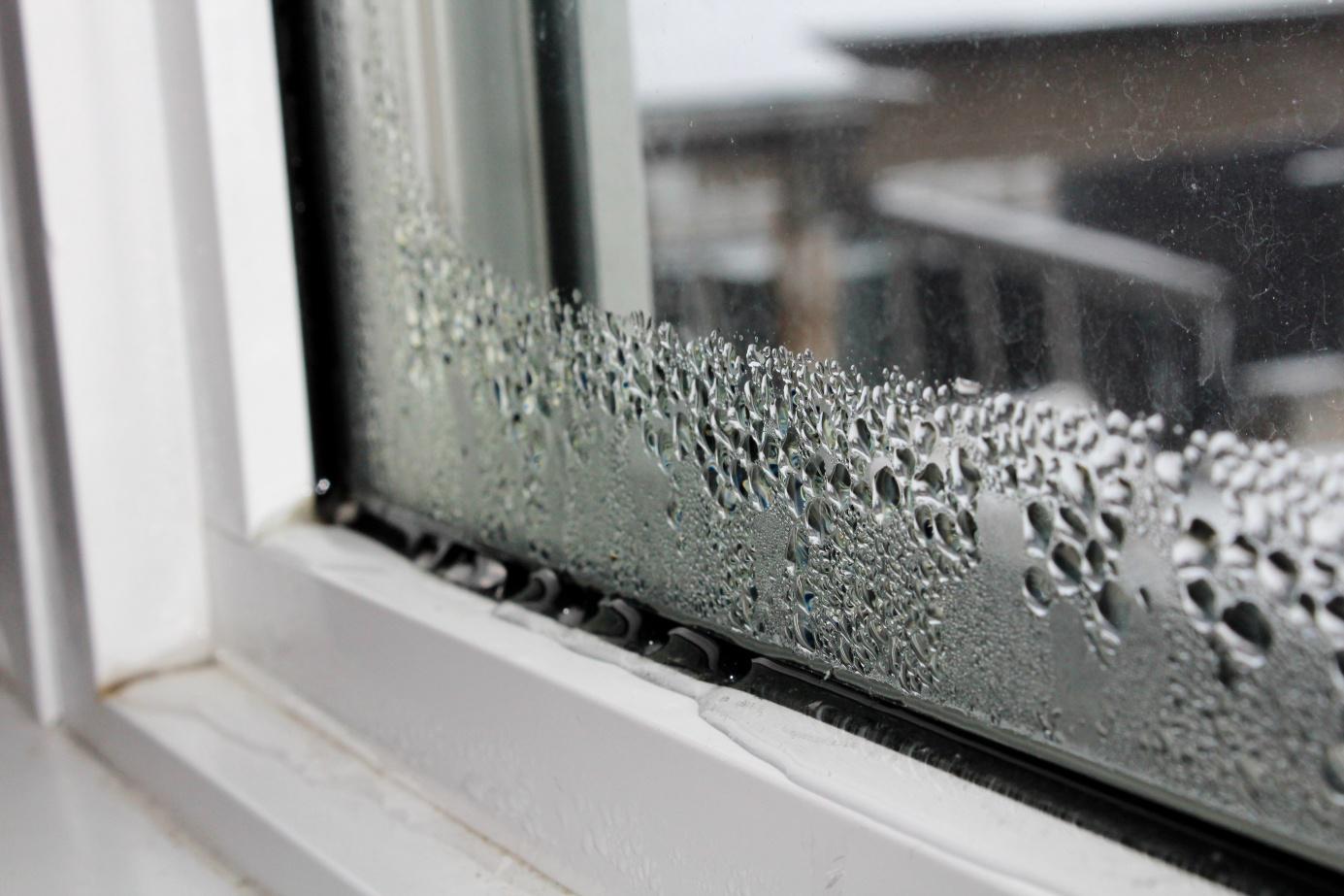 Wasser sammelt sich an einem Kunststofffenster