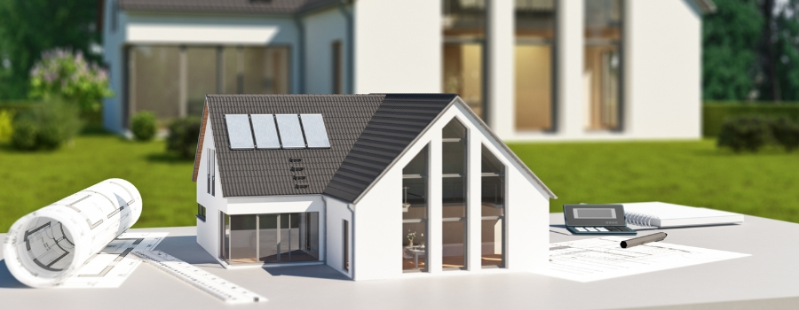 Modell eines modernen Einfamilienhauses mit großen Fensterflächen und Solarpanels, platziert neben Bauplänen und Lineal. Fensterplanung und individuelle Konfiguration bei meinfenster24 möglich.