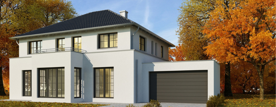 Weißes Einfamilienhaus mit umliegenden herbstlicher Baumlandschaft. Das Haus verfügt über große Fensterfronten sowie einer anliegenden Garage rechts, die bei meinfenster24 erhältlich sind.